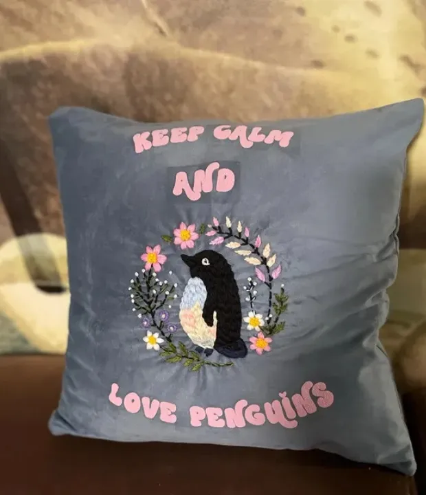 Customer embroidered penguin cushion with floral wreath