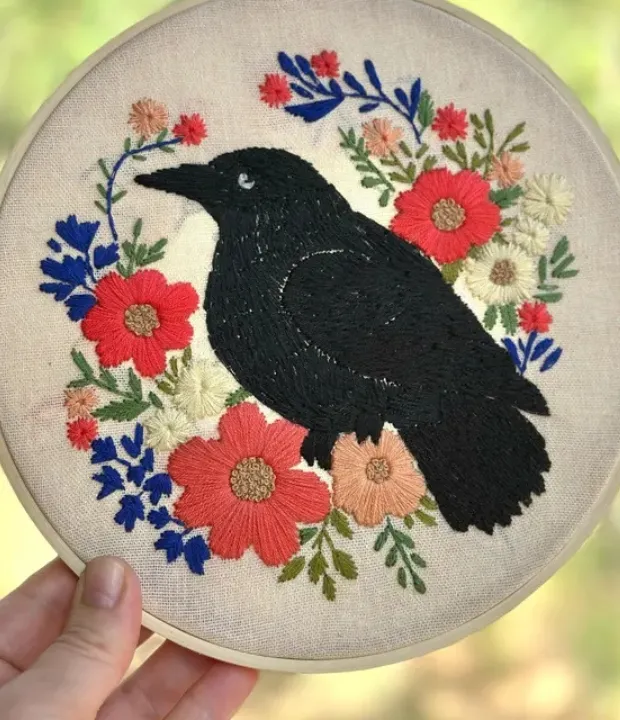 Customer embroidered crow surrounded by colorful flowers
